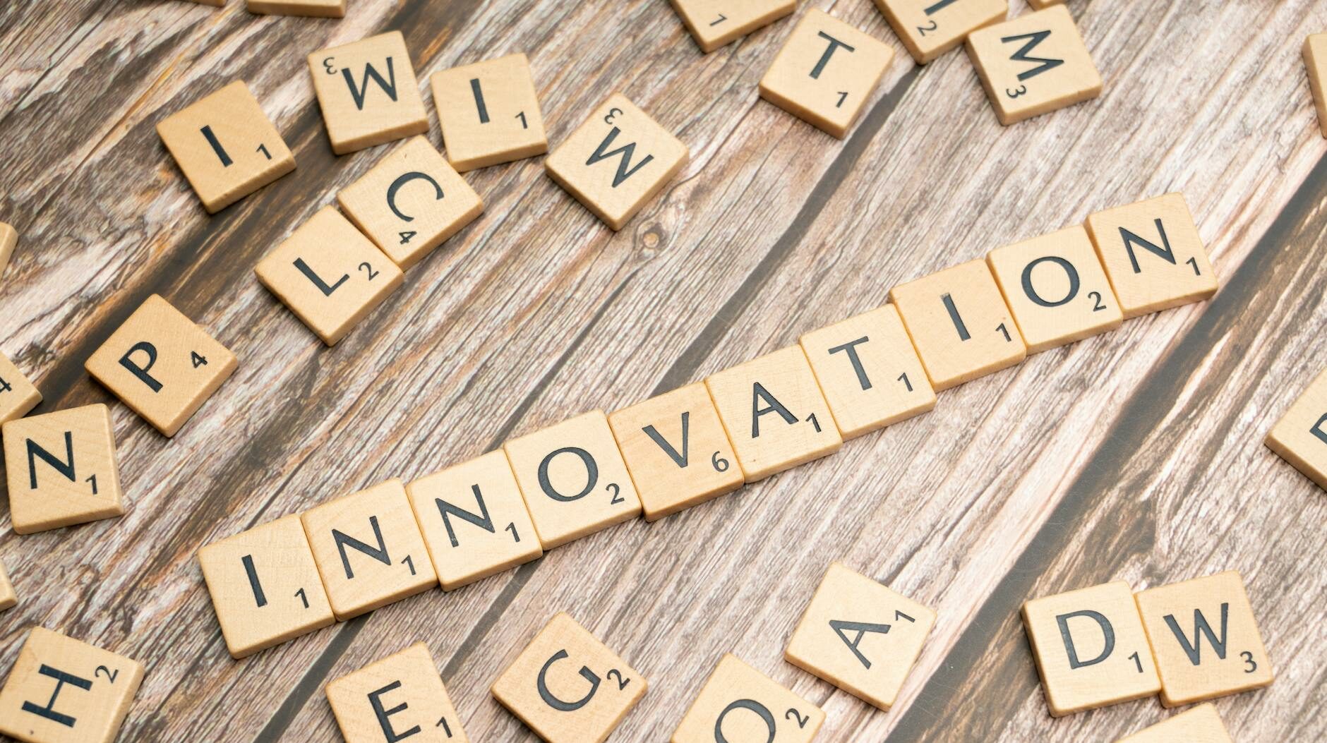Creative display of 'Innovation' spelled with wooden letter tiles on a wooden surface.